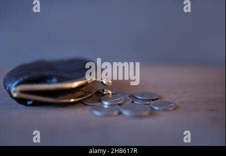 piccolo portafoglio vintage aperto con monete su sfondo di legno Foto Stock