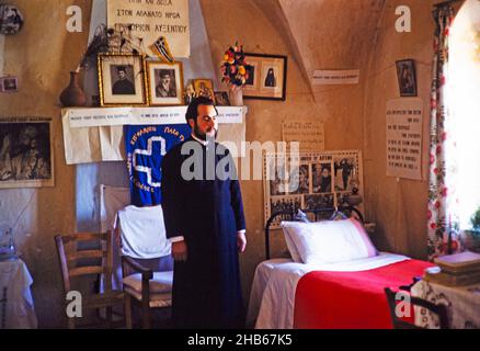 Sacerdote monaco in piedi presso il suo letto nella sua stanza al Monastero di Panagia Machairas, Lazanias, Cipro, 1963 Foto Stock