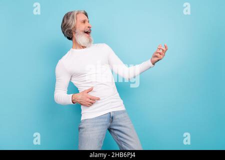 Ritratto di attraente uomo allegro grigio-capelli fingendo di suonare la chitarra ingannando isolato su sfondo di colore blu brillante Foto Stock