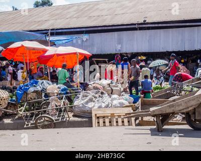 ARUSHA, TANZANIA - 16 MARZO 2017: Venditori e acquirenti in un mercato agricolo lungo l'autostrada di Arusha, Tanzania Foto Stock