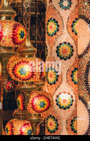 Immagine verticale con lampada a mosaico tradizionale turca o marocchina. Lampada colorata in vetro colorato sullo sfondo del negozio di souvenir sfocato con Foto Stock