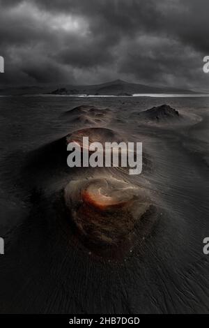 Cattura aerea di crateri vulcanici allineati in una pianura islandese nera. Foto Stock