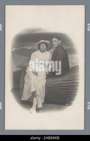 Ritratto studio di un uomo e una donna ignoti su una sedia da spiaggia in vimini, anonimo, in o dopo 1907 - c.. 1920, supporto fotografico, stampa in argento gelatina, altezza 96 mm x larghezza 75 mm Foto Stock