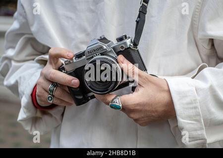 primo piano di un uomo che tiene una telecamera retrò, vista frontale Foto Stock