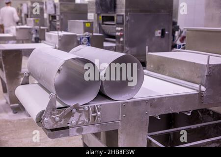 Panettiere per la preparazione di pasta su pasta sfoglia. Rotolatrice per pasta per la produzione di pasticceria, pane e baklava. Foto Stock