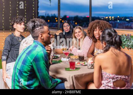 Gli amici festeggiano la vigilia di Capodanno sul balcone Foto Stock