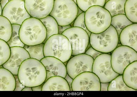 Le fette di cetriolo fresco verde si avvicinano all'intero fotogramma come sfondo Foto Stock