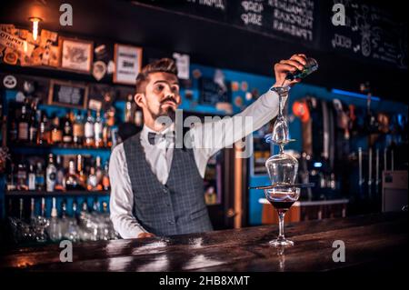 Il barman mescola un cocktail nella sala da beerhall Foto Stock