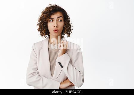 Immagine di una donna di vendita nervosa, una donna d'affari preoccupata che guarda via lo spazio della copia e che si alza in ansia su sfondo bianco Foto Stock