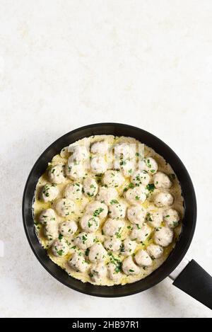 Polpette svedesi fatte in casa con salsa bianca cremosa in padella su sfondo di pietra chiaro con spazio copia. Vista dall'alto, piatto Foto Stock