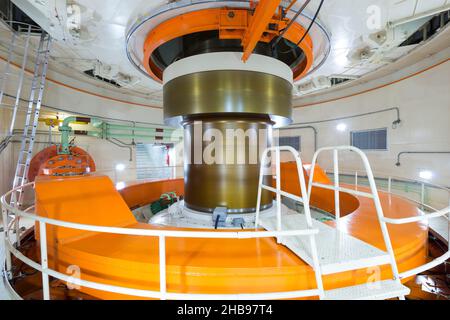 Hydro turbina elettrica che gira all'interno di una diga Foto Stock