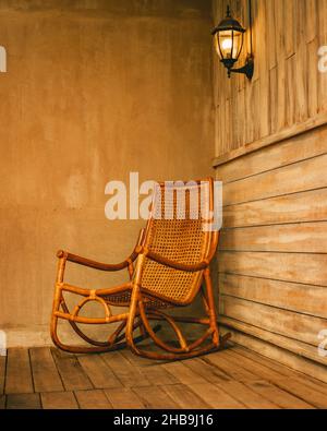 Scatto verticale di una sedia a dondolo in legno su un patio in legno Foto Stock