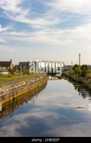 DUBLINO, IRLANDA - 25 luglio 2021: Un colpo verticale di un fiume con riflesso del cielo nel distretto docklands di Dublino Foto Stock