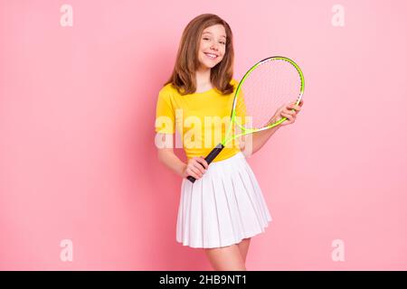 Foto di giovane ragazza felice sorriso positivo sportivo tenere racket tennis gioco isolato su sfondo rosa Foto Stock