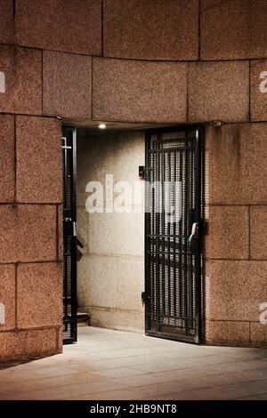 Immagine ad alto contrasto di un gateway in metallo nero con parete a blocchi di marmo Foto Stock