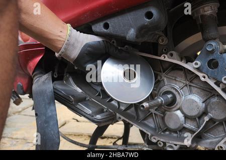 Scooter moto CVT cambio marcia e frizione riparazione mano del meccanico primo piano Foto Stock