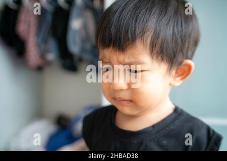 Piccolo ragazzo triste offeso piangere in casa ragazzo emozione Foto Stock