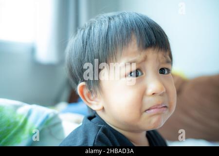 Piccolo ragazzo triste offeso piangere in casa ragazzo emozione Foto Stock