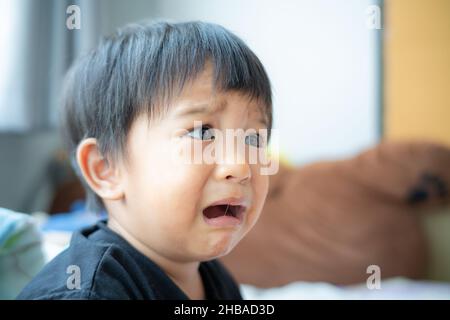 Piccolo ragazzo triste offeso piangere in casa ragazzo emozione Foto Stock