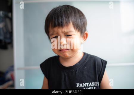 Piccolo ragazzo triste offeso piangere in casa ragazzo emozione Foto Stock