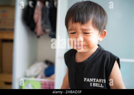 Piccolo ragazzo triste offeso piangere in casa ragazzo emozione Foto Stock