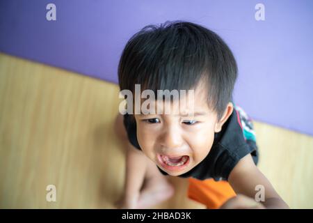 Piccolo ragazzo triste offeso piangere in casa ragazzo emozione Foto Stock