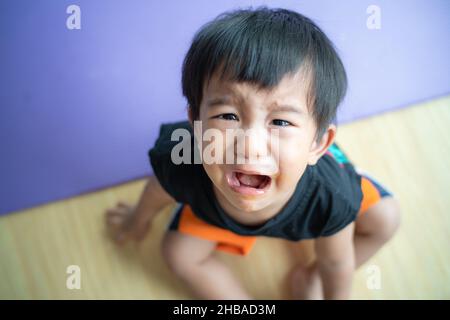 Piccolo ragazzo triste offeso piangere in casa ragazzo emozione Foto Stock