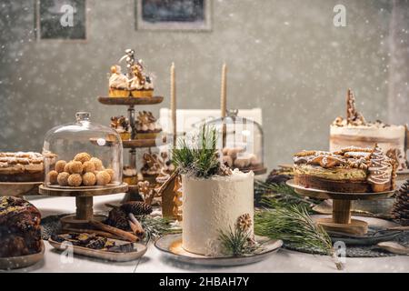 Tavola di dolci fantasia con varietà di dessert di Natale, torta di pan di zenzero, palle di cocco, cupcakes, babka Foto Stock