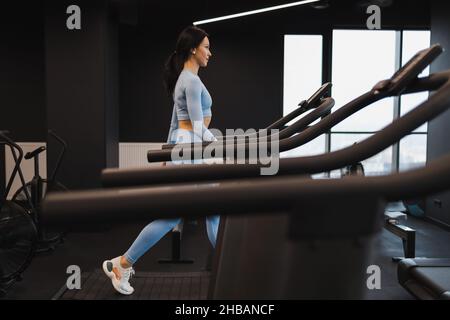 Fitness donna che cammina sul tapis roulant in palestra Foto Stock