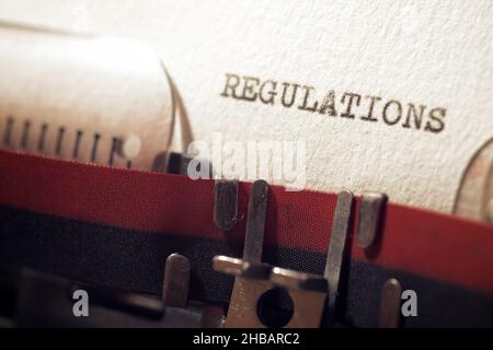La parola regolamenti scritto con una macchina da scrivere. Foto Stock