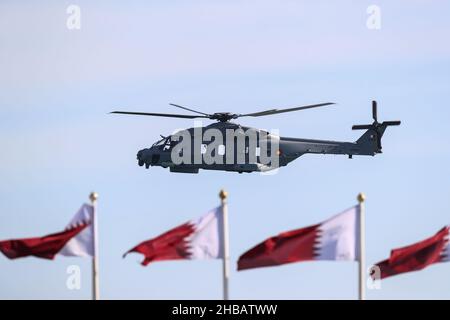 Doha, Qatar. 18th Dic 2021. Un elicottero dell'aeronautica vola attraverso l'aria durante una parata militare come parte delle celebrazioni della Giornata Nazionale del Qatar. Credit: Mahmoud Hefnawy/dpa/Alamy Live News Foto Stock