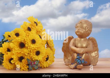 Fiori e Angel Statua con farfalle su sfondo Blue Sky Foto Stock