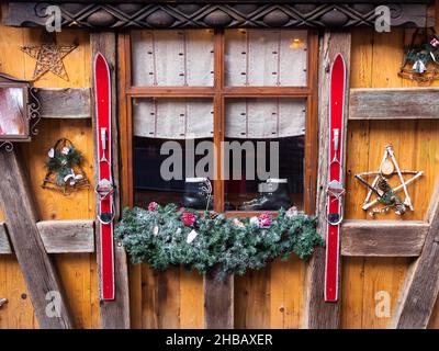 Colmar, Francia - 13 dicembre 2021: Un paio di vecchi sci decorativi come decorazione invernale sulla facciata di una casa tradizionale a Colmar, Francia Foto Stock