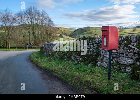 Una casella postale rurale nel villaggio Peak District di Stanshope con una vista giù Hall Dale verso Dovedale in lontananza, Staffordshire, Inghilterra Foto Stock