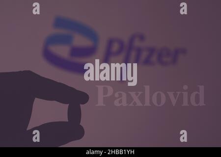Firenze, Italia, Dicembre 18th 2021, mano che tiene una pillola con il logo 'Pfizer' come sfondo, concetto di Paxlovid Foto Stock