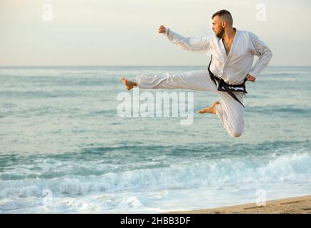 L'uomo adulto sta addestrando il calcio nel salto Foto Stock