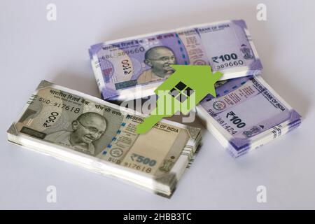 Pila di cento e cinquecento rupie indiane note fresche su sfondo bianco, pacchetto di banconote indiane con carta chiave casa, futuro casa pla Foto Stock