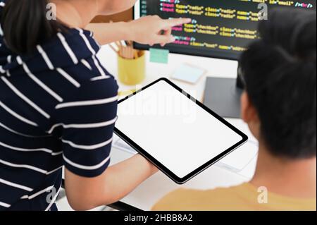 Il team di programmatori con tablet e computer sta programmando per presentare i clienti. Foto Stock