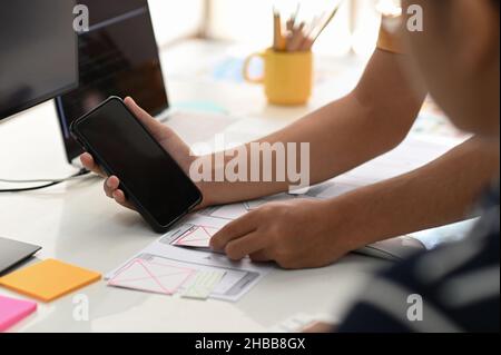 Team di progettisti di app per smartphone che lavorano insieme per progettare un nuovo progetto. Foto Stock