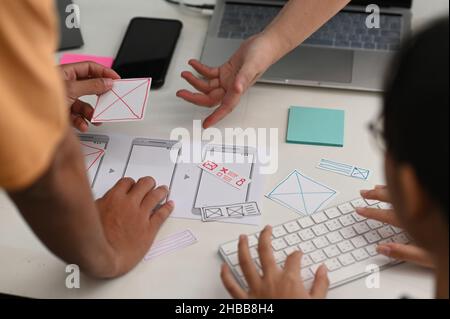 Team di progettisti di app per smartphone che lavorano insieme per progettare un nuovo progetto. Foto Stock