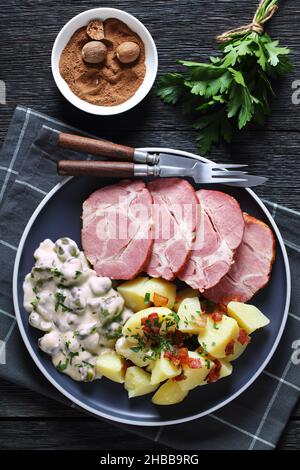 Judd Mat Gaardebounen, colletto di maiale affumicato con fagioli larghi sbolliti cotti con salsa cremosa e patate bollite su un piatto, piatto nazionale di Luxem Foto Stock
