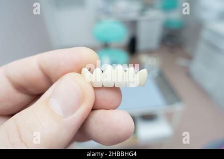 ponti dentali in ceramica metallica nelle mani di un medico Foto Stock