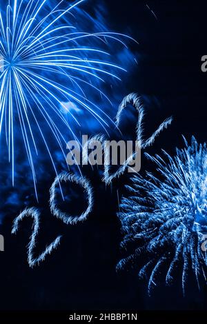 Felice anno nuovo 2022. Numeri scintillanti in fiamme anno 2022 con fuochi d'artificio su sfondo nero. Foto Stock