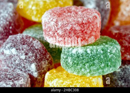 Un primo piano di una pila decentrata di dolci rotondi, colorati, aromatizzati alla frutta e zuccherati, comunemente noti come pastiglie. Foto Stock