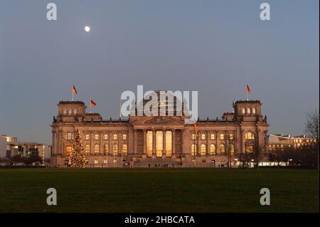 16.12.2021, Berlino, Germania, Europa - la luce della sera si riflette nelle finestre dell'edificio del Reichstag (Dieta Imperiale) nel quartiere Mitte. Foto Stock