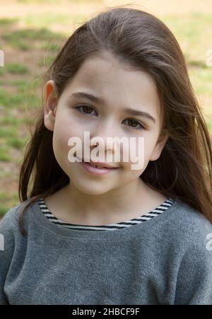 Un ritratto estivo di location di una ragazza di 7 anni, razza mista ispanica e caucasica Foto Stock