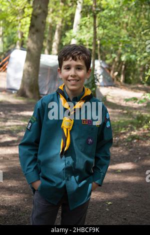 Un ritratto di un ragazzo scout campeggio nei boschi nel Regno Unito Foto Stock