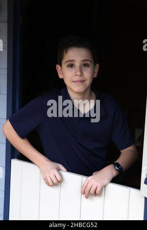 Ritratto di un ragazzo di dodici anni illuminato da luce ambientale Foto Stock