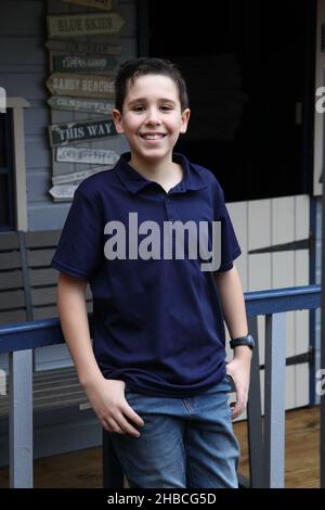 Ritratto di un ragazzo di dodici anni illuminato da luce ambientale da un attico Foto Stock