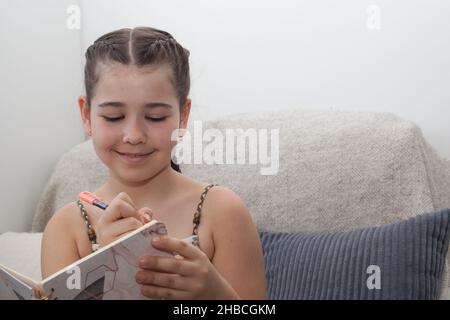 Un bambino felice che scrive nel suo giornale quotidiano Foto Stock